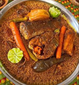 a plate of food with meat and vegetables on a table at One Love - One Heart Lodge in Tanji