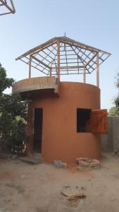 an orange building with a balcony on top of it at One Love - One Heart Lodge in Tanji