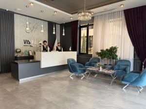 two men standing at a counter in a lobby at VIS Palm Hotel Ganja in Ganja