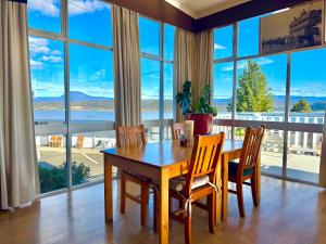 a dining room with a table and chairs and large windows at Mountain View Country Inn in Deloraine