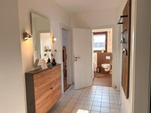 a hallway with a bathroom with a sink and a toilet at Jahnstraße 37 - Ferienwohnung Hufnagel in Bodenwerder
