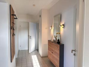 a hallway with a wooden dresser and a mirror at Jahnstraße 37 - Ferienwohnung Hufnagel in Bodenwerder