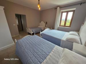 a bedroom with two beds and a chair and a window at Bed&Wine Terrae Tiferni in Gioia Sannitica