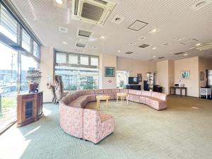 a large living room with a couch and a table at Hotel Livemax Tagajo in Tagajo
