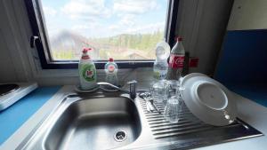 a kitchen sink with soda bottles and a window at Retro chata Vlastějovice in Vlastějovice