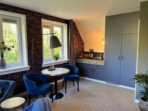 a room with a table and chairs and a kitchen at Het Pauwtje in Zoutelande