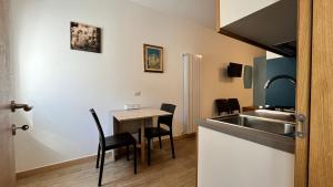 a kitchen with a sink and a table with chairs at Residenza Montegrappa in Peschici