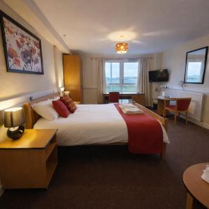 a hotel room with a large bed and a table at The Brae Hotel in Brae