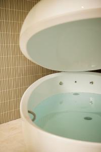 a bathroom with a bathtub with blue water in it at Van der Valk Theaterhotel Almelo in Almelo