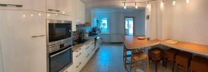a large white kitchen with a counter and a table at Statesman Suite in Königstein an der Elbe