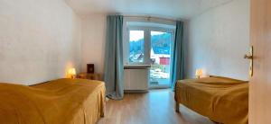 a bedroom with two beds and a large window at Statesman Suite in Königstein an der Elbe