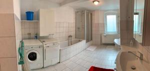 a bathroom with a washing machine and a tub at Statesman Suite in Königstein an der Elbe