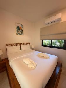 a bedroom with a bed with white sheets and a window at Srithanu Escape 2 in Srithanu +12 photos