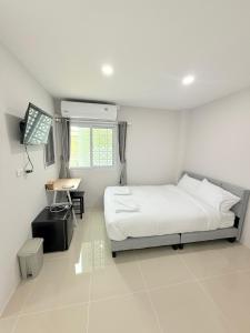 a bedroom with a bed and a desk in it at Dana Residence in Ko Yao Noi