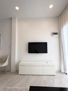 a white living room with a flat screen tv on a white wall at Srithanu Escape 2 in Srithanu