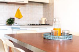 a bottle of orange juice on a table in a kitchen at Mamì Altanea Village in Duna Verde
