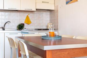 a kitchen with a table with a bottle of juice on it at Mamì Altanea Village in Duna Verde