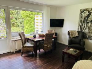 a living room with a dining room table and chairs at Haus Larum App. 3 in Scharbeutz