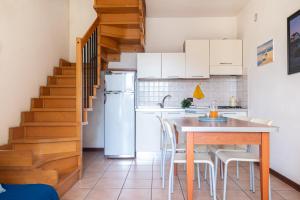a kitchen with a table and a refrigerator at Mamì Altanea Village in Duna Verde +14 photos