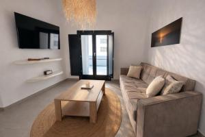 a living room with a couch and a coffee table at Rosaviglia Luxury Villa - an Oia Private Hideaway in Oia