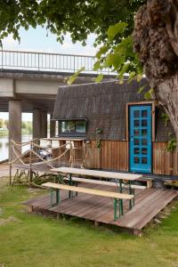 a house with a blue door sitting on a wooden deck at Glampervan Rietje in Den Bosch +6 photos