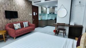 a living room with a red couch and a kitchen at 60 Inn Saigon in Ho Chi Minh City