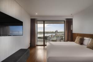 a bedroom with a bed and a balcony with a table at Hotel SB BCN Events 4* Sup in Castelldefels +41 photos