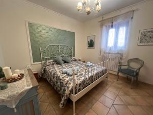 a bedroom with a bed and a chair in it at Rhome country lodge in La Massimina-Casal Lumbroso