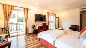 a bedroom with a large bed and a television at Cana Boutique Stay in Porvorim +22 photos