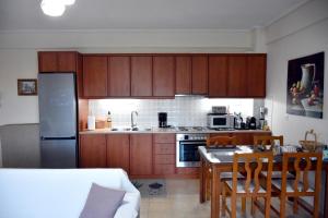 a kitchen with wooden cabinets and a table with chairs at Seaside apartment platana kimis evoia in Kymi