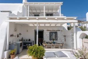 a white villa with a kitchen and a patio at Villa Moon with Private Swimming Pool in Aspro Chorio Paros