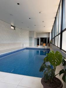 a large swimming pool with a potted plant in a building at Shamshod Mountain Resort in Yangiobod