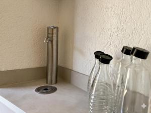 three glass vases sitting on a counter next to a wall at W-Apartments - Spacious Parking, EV-Station, Washer & Private Garden in Offenburg +13 photos
