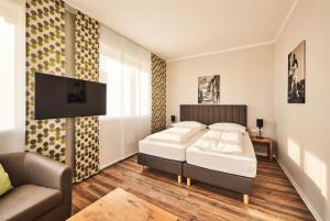 a bedroom with a bed and a couch at ADAPT APARTMENT HOTEL Siegen in Siegen +47 photos