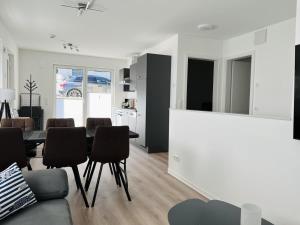 a white living room with a table and chairs at OceanHome in Scharbeutz
