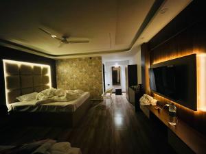 a hotel room with a bed and a flat screen tv at White Coastal Beach Resort in Mandarmoni