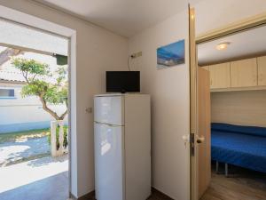 a room with a refrigerator with a tv on top of it at Club del Sole Roseto degli Abruzzi Easy Camping Village in Roseto degli Abruzzi