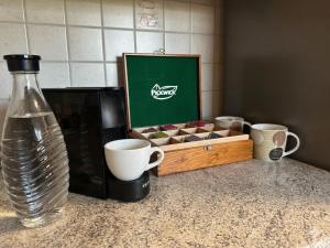 a kitchen counter with a box of cups and a vase at W-Apartments - Spacious Parking, EV-Station, Washer & Private Garden in Offenburg
