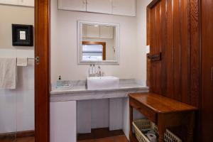 a bathroom with a sink and a mirror at Brooklyn Manor in Pretoria +49 photos