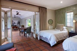 a bedroom with a bed and a dining room at Brooklyn Manor in Pretoria