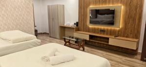 a hotel room with two beds and a flat screen tv at White Coastal Beach Resort in Mandarmoni