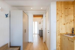 a kitchen with white walls and a wooden door at Aghèl Luxury Room in Recanati +87 photos