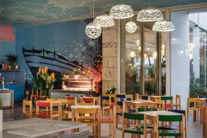 ein Restaurant mit farbenfrohen Stühlen, Tischen und Kronleuchtern in der Unterkunft Amadria Park Kids Hotel Andrija in Šibenik