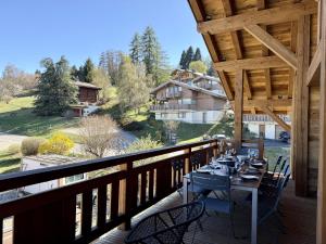 a wooden balcony with a table and chairs on it at Chalet Suzane - Panorama Mont-Blanc & jacuzzi in Combloux