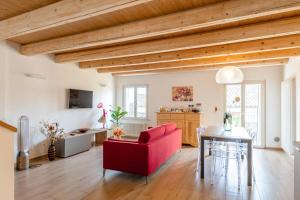 a living room with a red chair and a table at Aghèl Luxury Room in Recanati
