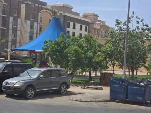 a car parked in a parking lot with a blue tent at شقة vip غرفتين نوم in Jeddah