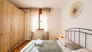 a bedroom with a bed and a window at Lake Apartment by GardaDoma in Brenzone sul Garda