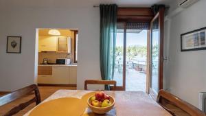 a kitchen and a table with a bowl of fruit on it at Lake Apartment by GardaDoma in Brenzone sul Garda