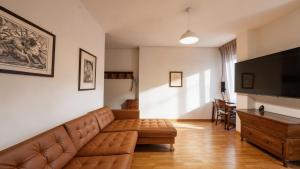 a living room with a couch and a flat screen tv at Lake Apartment by GardaDoma in Brenzone sul Garda