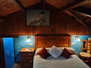 a bedroom with a bed and a woman sitting on a table at Río da Cruz in Cariño